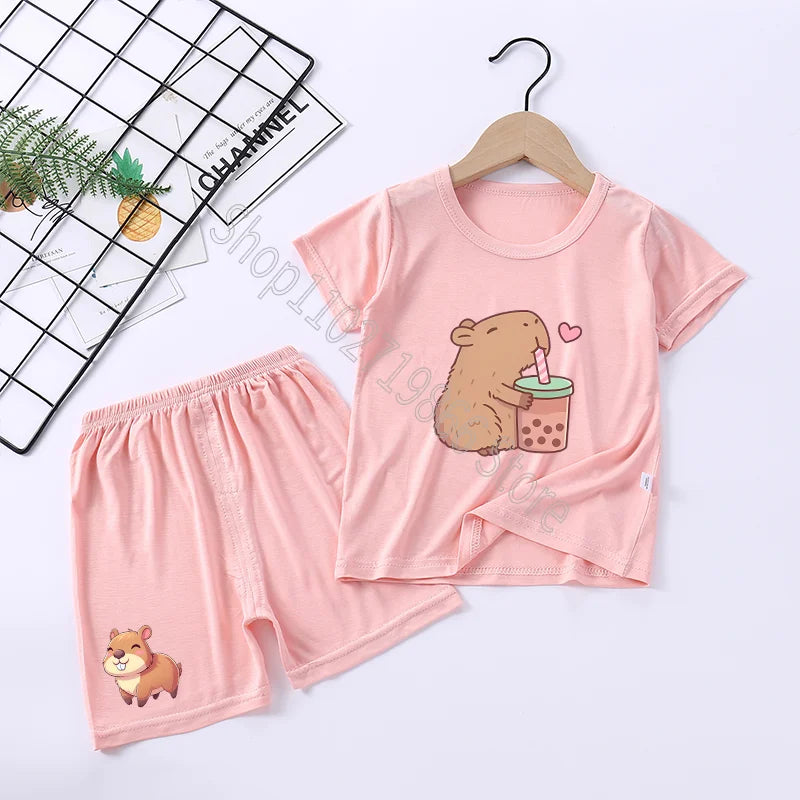 Pink children's pajama set with capybara cartoon design on a white background
