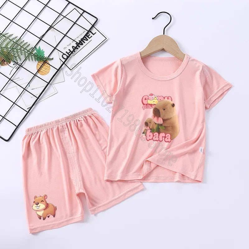Pink children's pajama set with cartoon capybara design on a white background