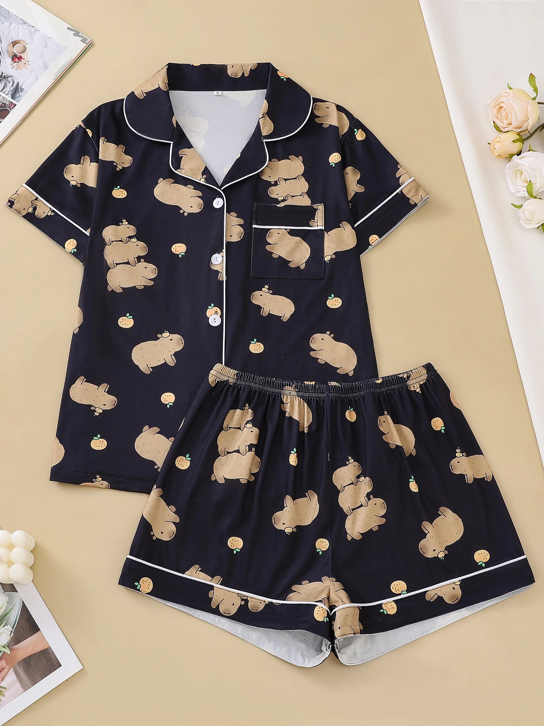 Navy blue pajama set with capybara print on a beige surface