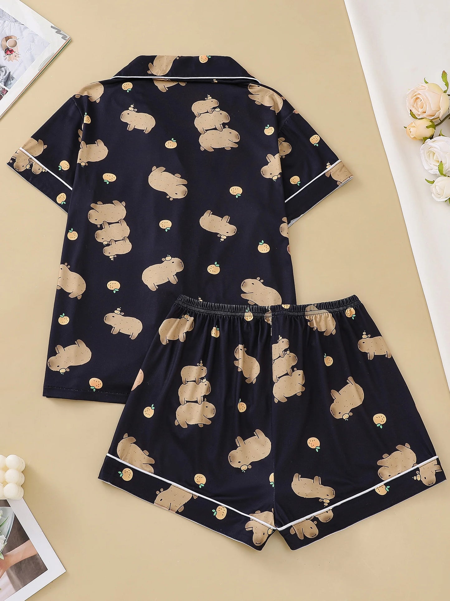 Navy blue pajama set with beige capybara print on a beige background