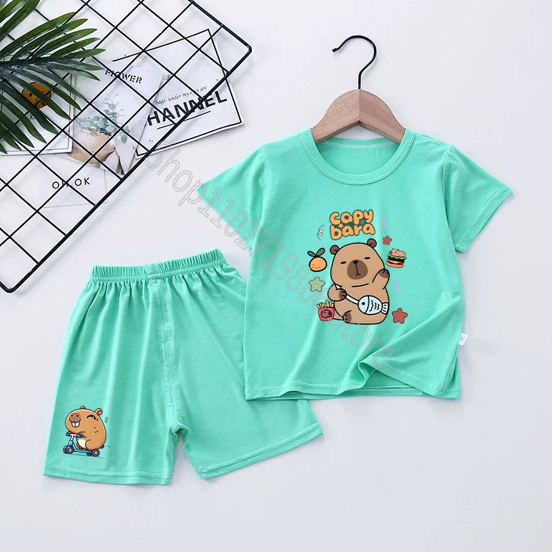 Children's green t-shirt and shorts set with capybara cartoon character on a white background