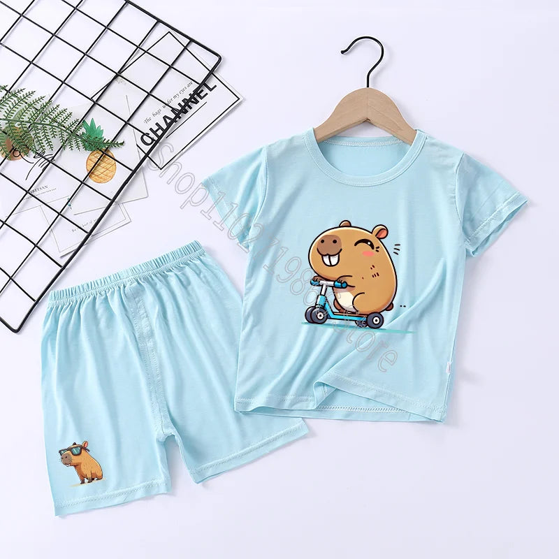 Children's light blue t-shirt and shorts set with a capybara cartoon design on a white background.