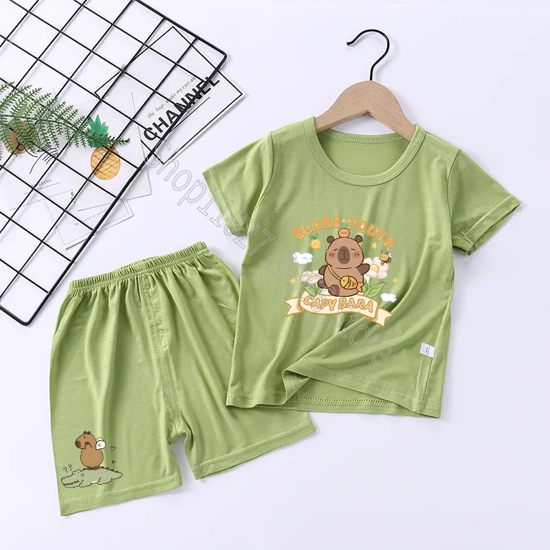 Green children's pajama set with capybara design on a white background
